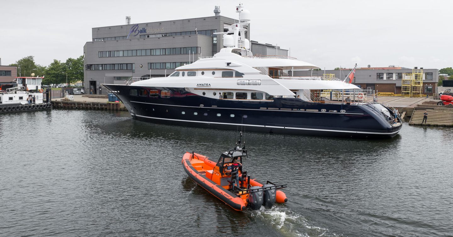 Royal Hakvoort Superyacht Awatea docked post-refit next to under way tugboat