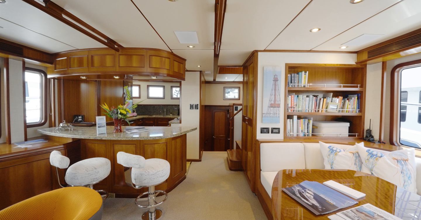 Nordhavn 75 EYF saloon and galley with breakfast bar, dining area and open-plan living space