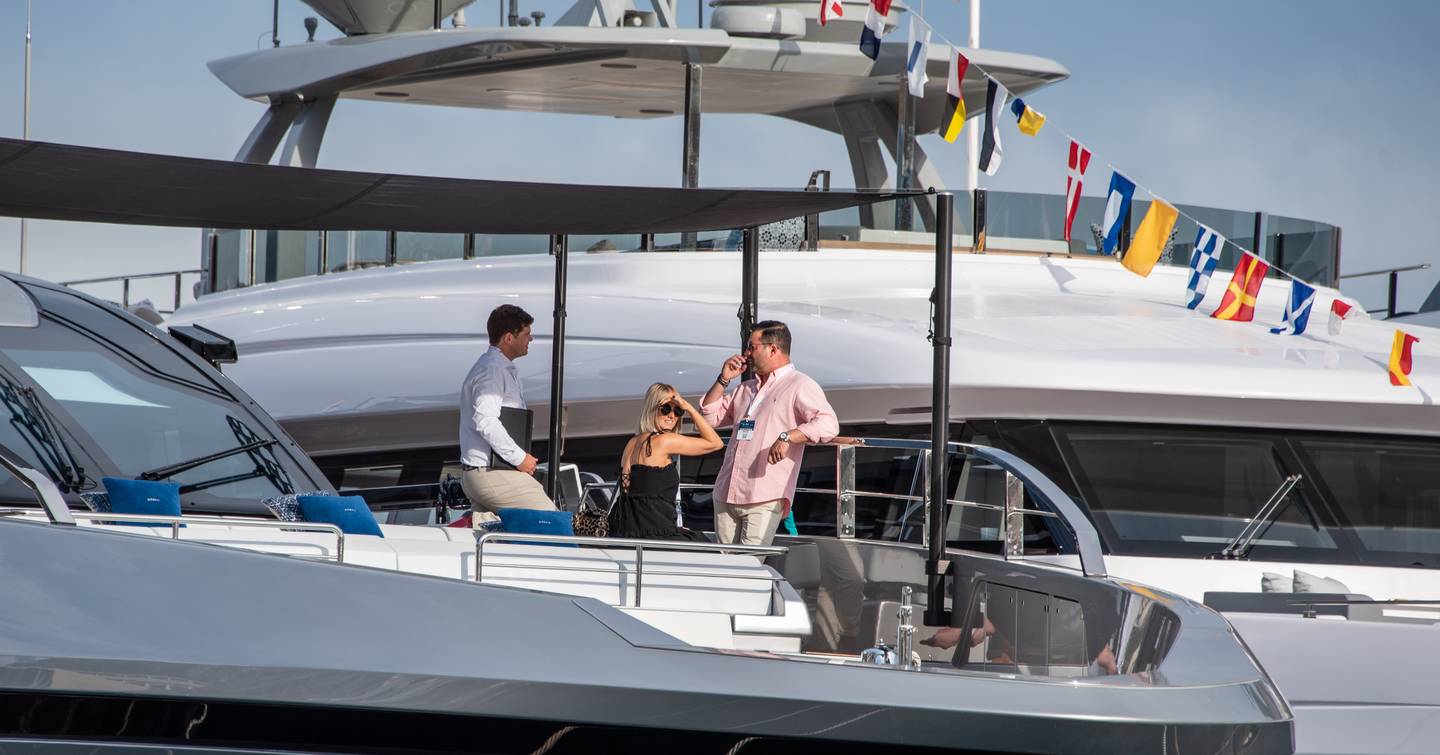 Visitors to the Monaco Yacht Show standing on deck with a representative during a tour.