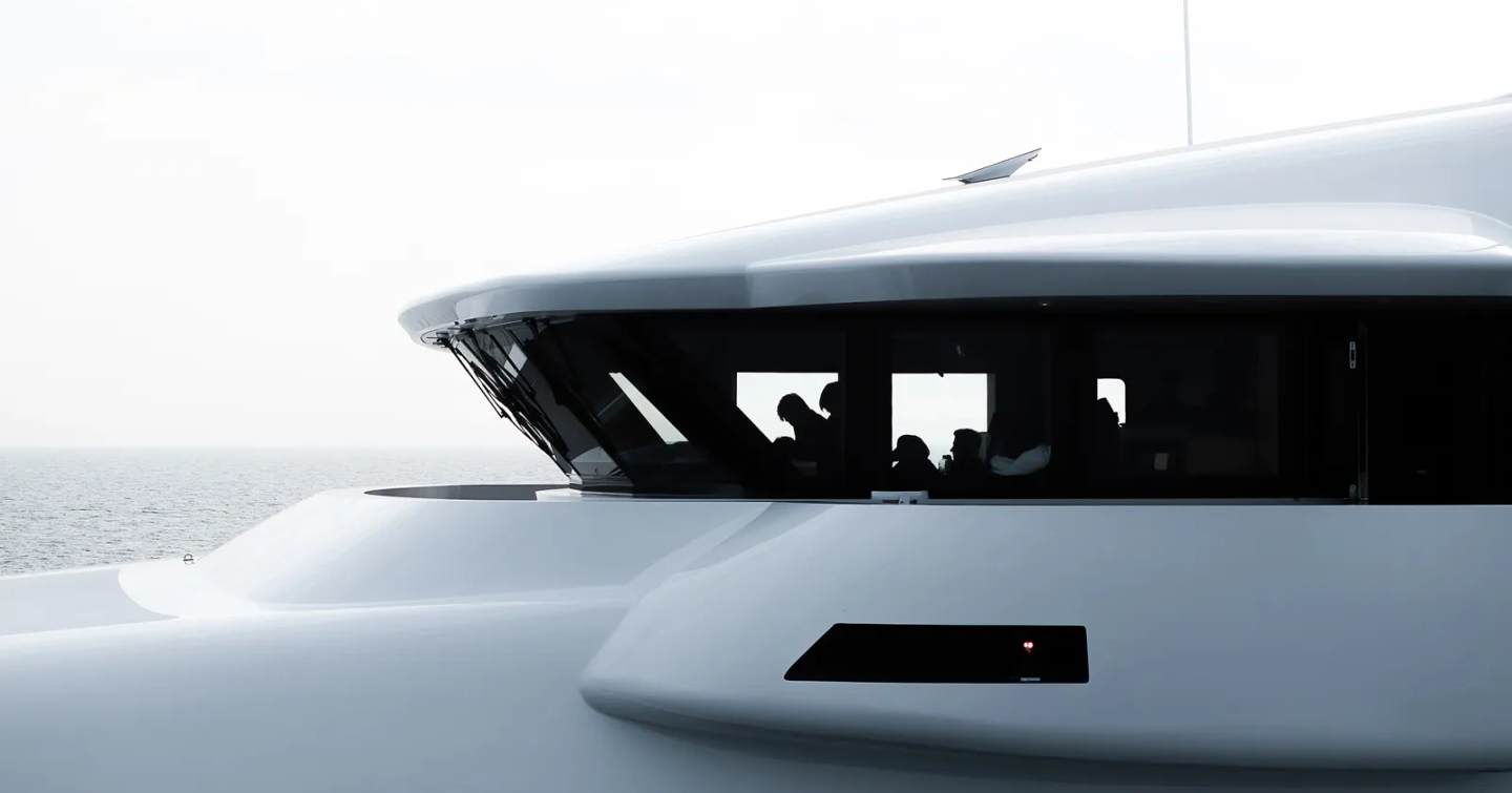 Close up of Superyacht Draak superstructure and crew in upper deck while under way 