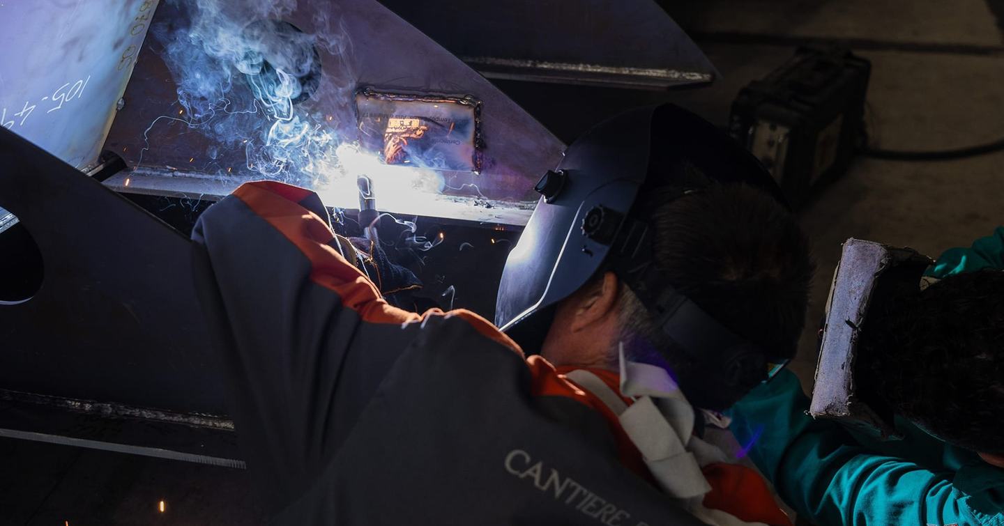 Man welding keel on explorer yacht Amiga