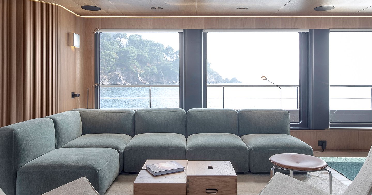 Explorer Yacht Cabana main saloon light blue L-shaped sofa and wooden coffee table 