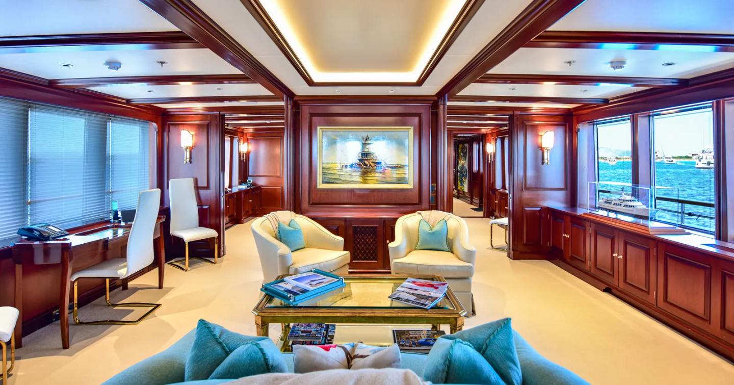 Superyacht Berilda's main saloon with teak detailing and cream chairs 