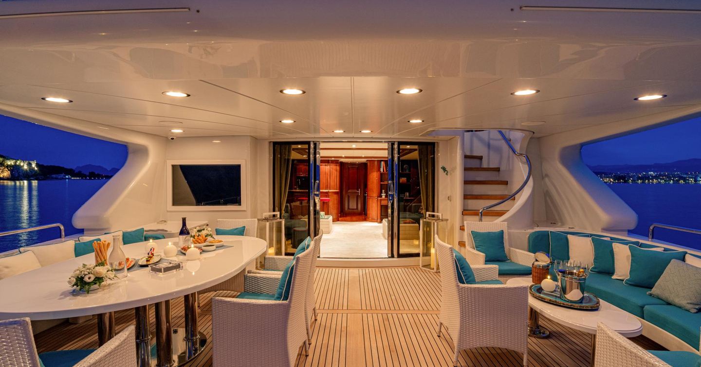 Superyacht Bang! bridge deck aft with shaded alfresco dining area and blue seating
