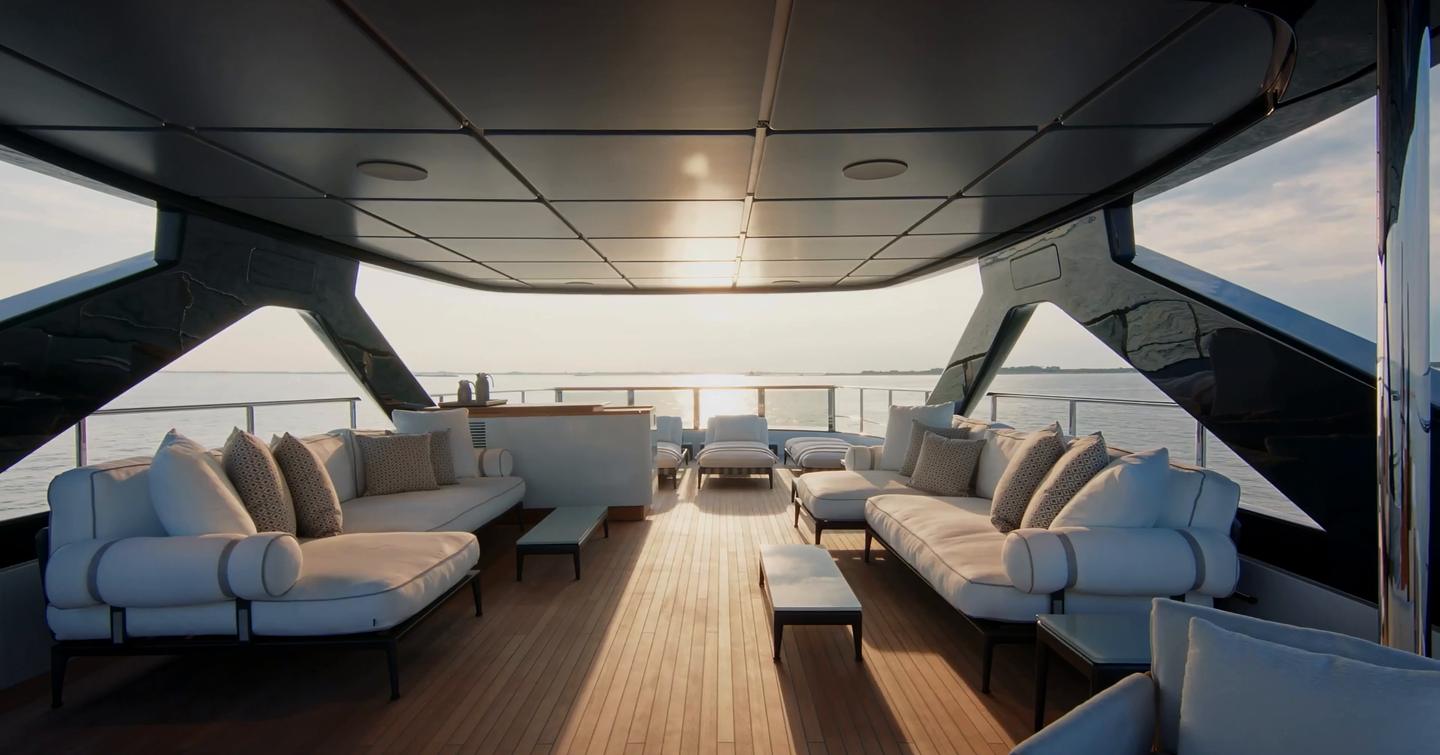 Custom Line Navetta 38 sundeck lounge with large sofas, shaded seating and wet bar area aft