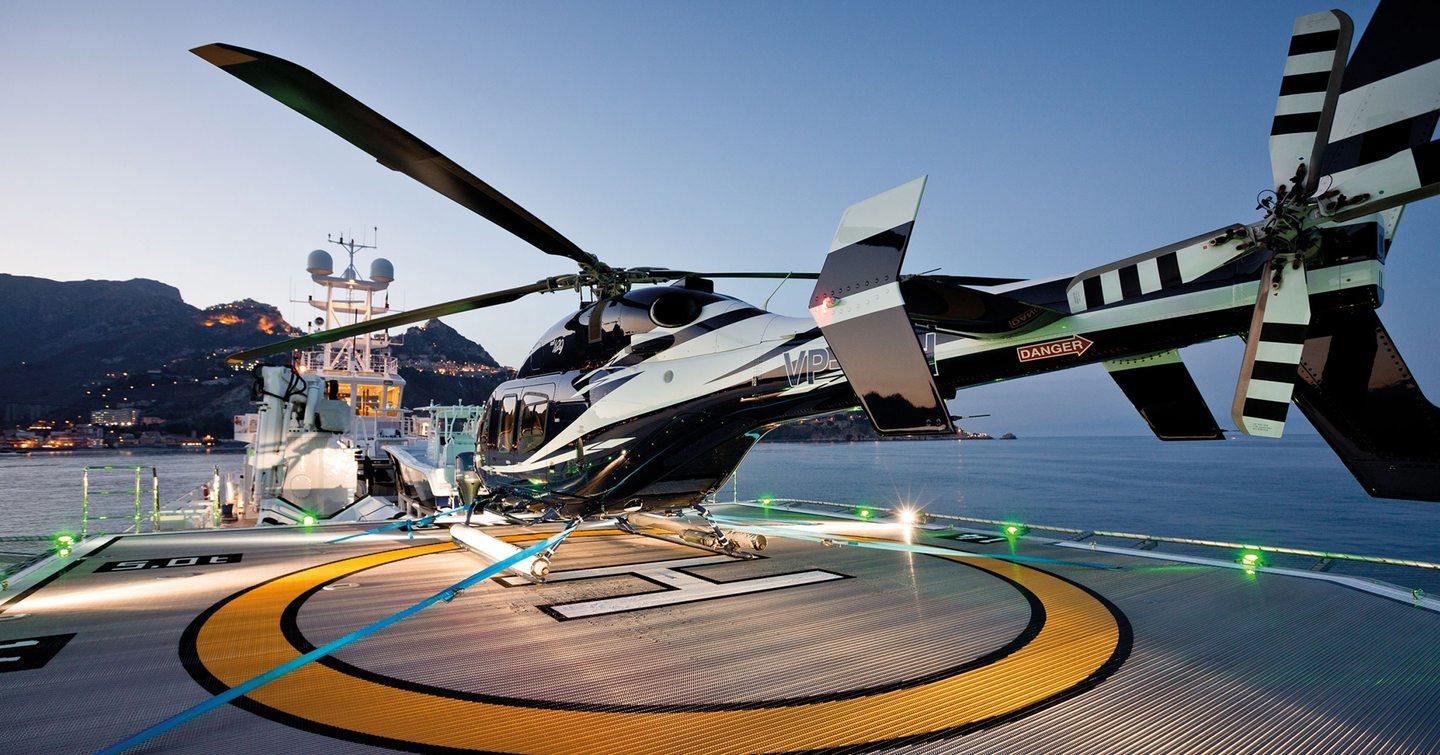 Helicopter on helipad on support yacht 