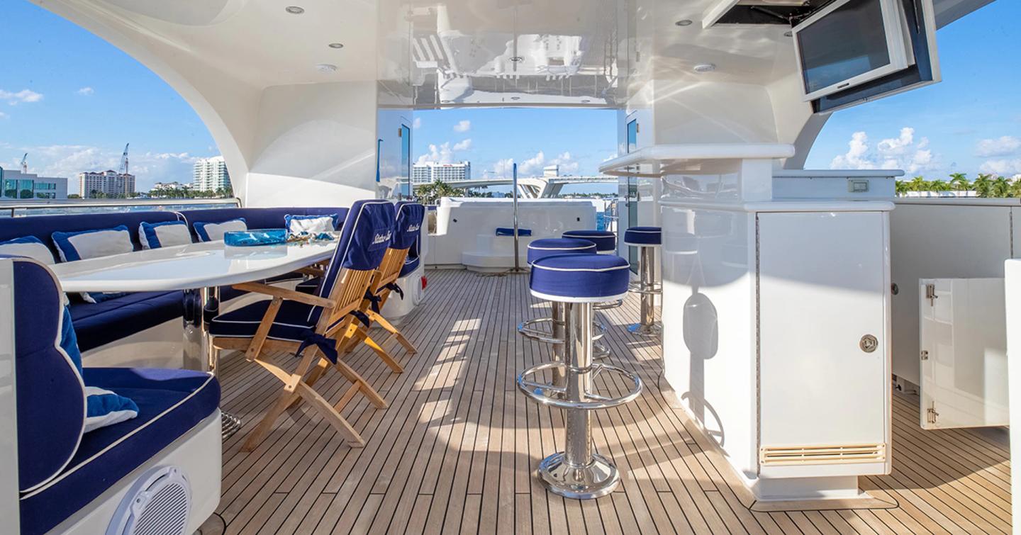 Superyacht Status Quo's flybridge with bar area and shaded dining table