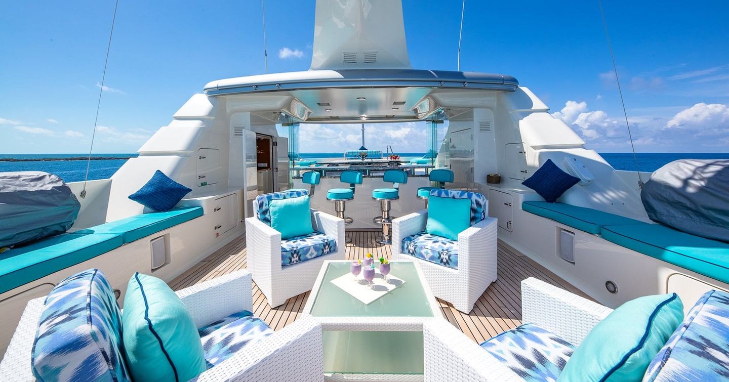 Motor yacht Nita K II's sundeck with seating area and bar with blue furnishings 