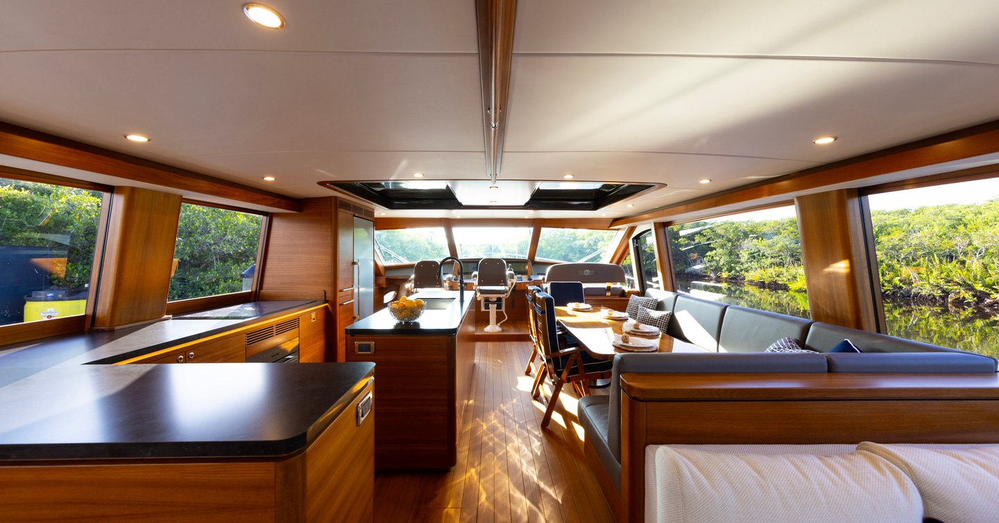 Palm Beach PB85 Sedan motor yacht interior with hardwood finishes, L-shaped sofa and helm station