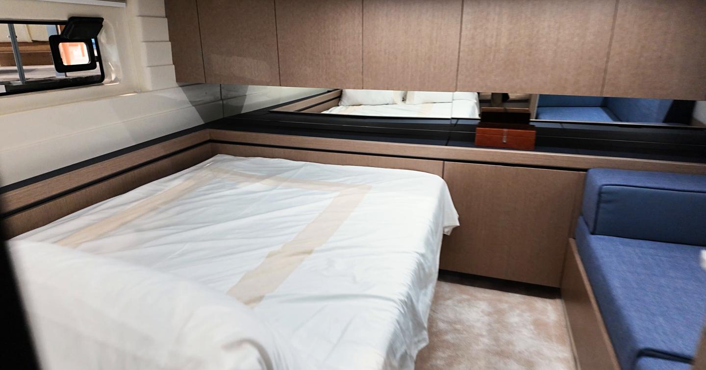 Amidships cabin on the Aiata Sunfinder 50 with a double berth, side storage cabinets and mirror along the bulkhead.