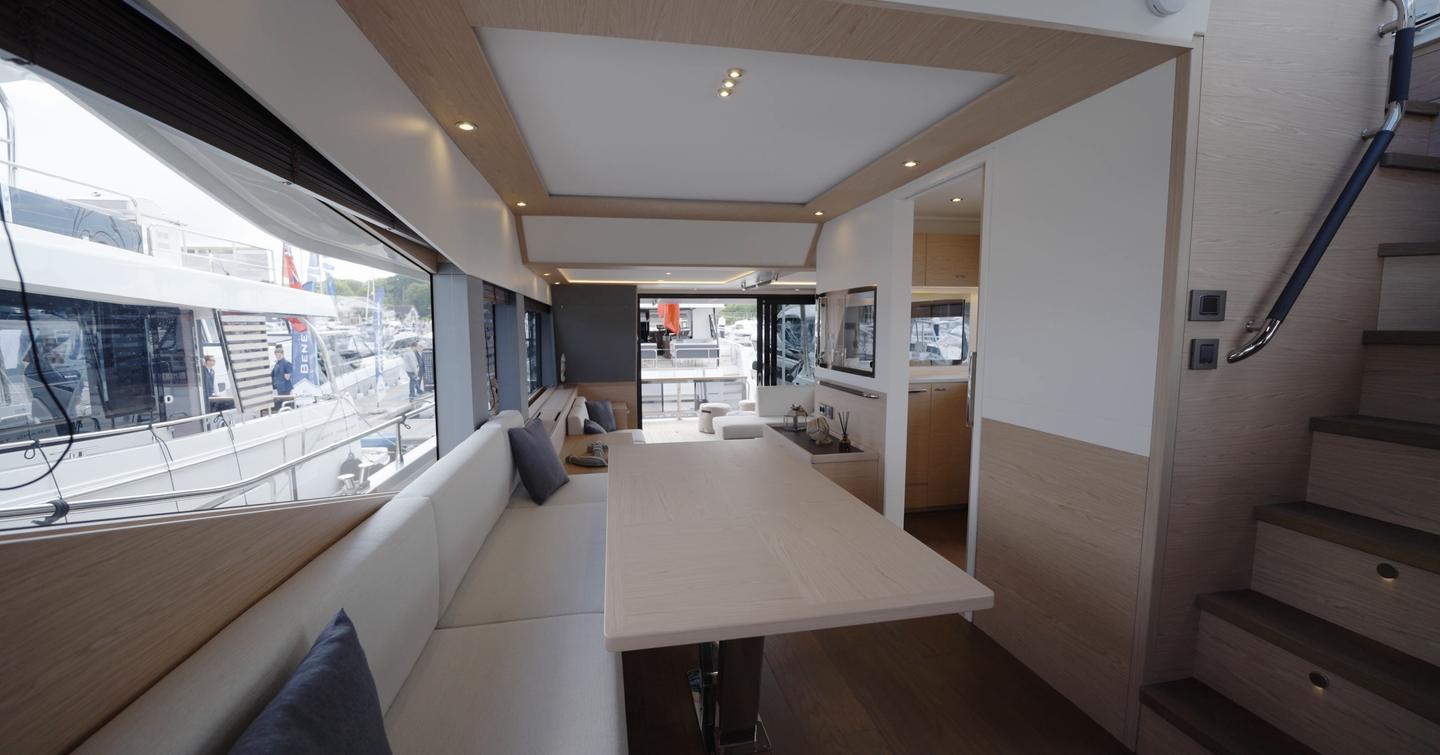 Beneteau Grand Trawler 63 main deck dinette with U-shaped seating and panoramic side windows