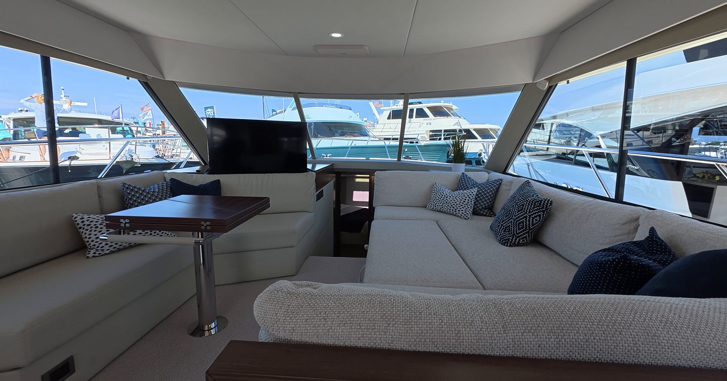 Maritimo M50 main saloon seating area with wraparound sofa, dining table and panoramic windows