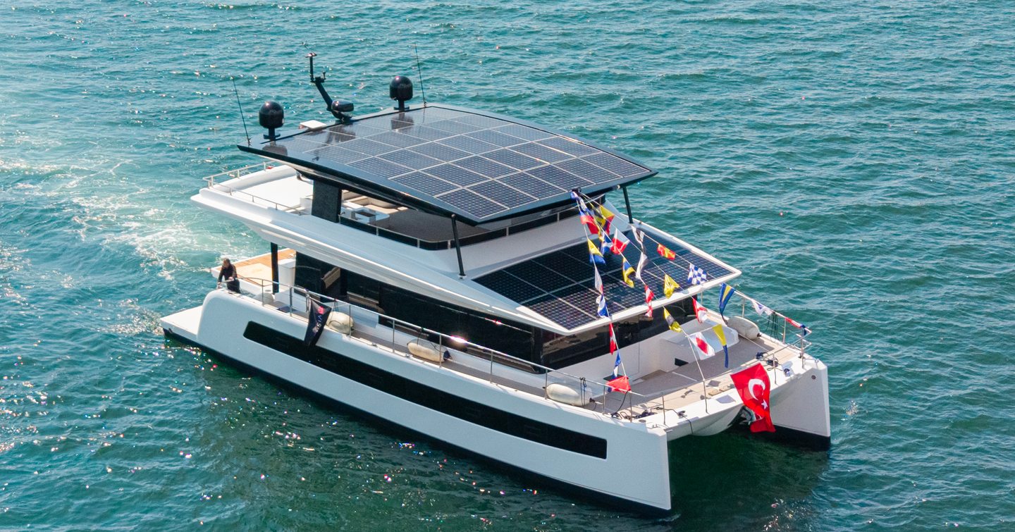 VisionF 65 catamaran under way with bunting on foredeck 