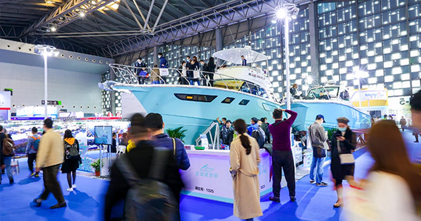 Blue hulled motor yacht on display at China International Boat Show, surrounded by visitors.