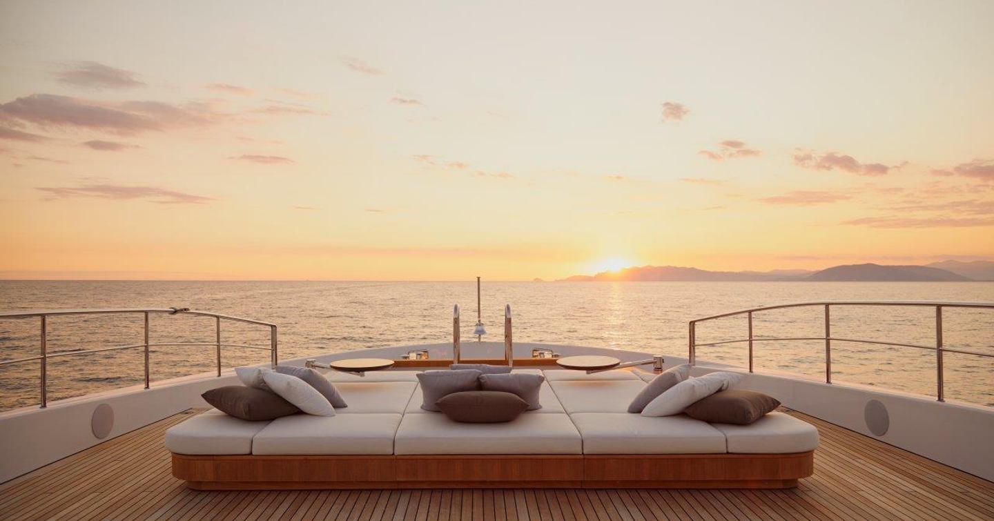 Aft lounge area of Benetti Diamond 145 INK superyacht with sunsetting