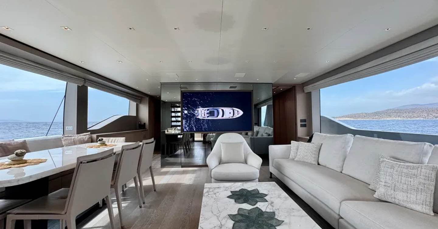 Motor yacht Judy's main saloon with dining area and white furniture