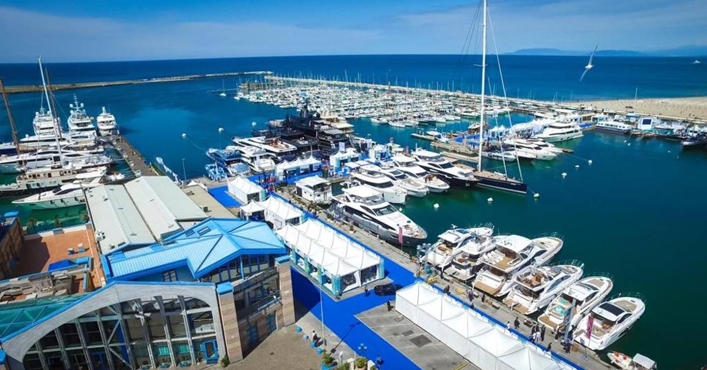 Overview of the Versilia Yachting Rendezvous, many motoryachts berthed in marina with the sea in the background.