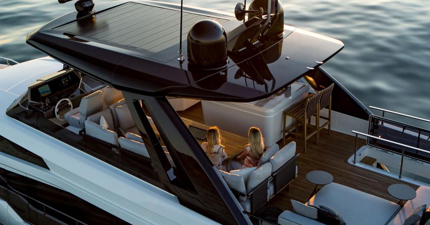 Two females sitting under covered hardtop area of flybridge on Ferretti Yachts 780