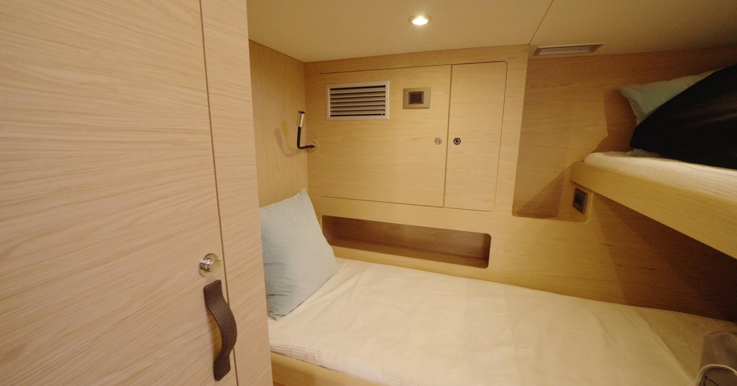 Beneteau Grand Trawler 63 crew cabin with over-under bunks and built-in storage