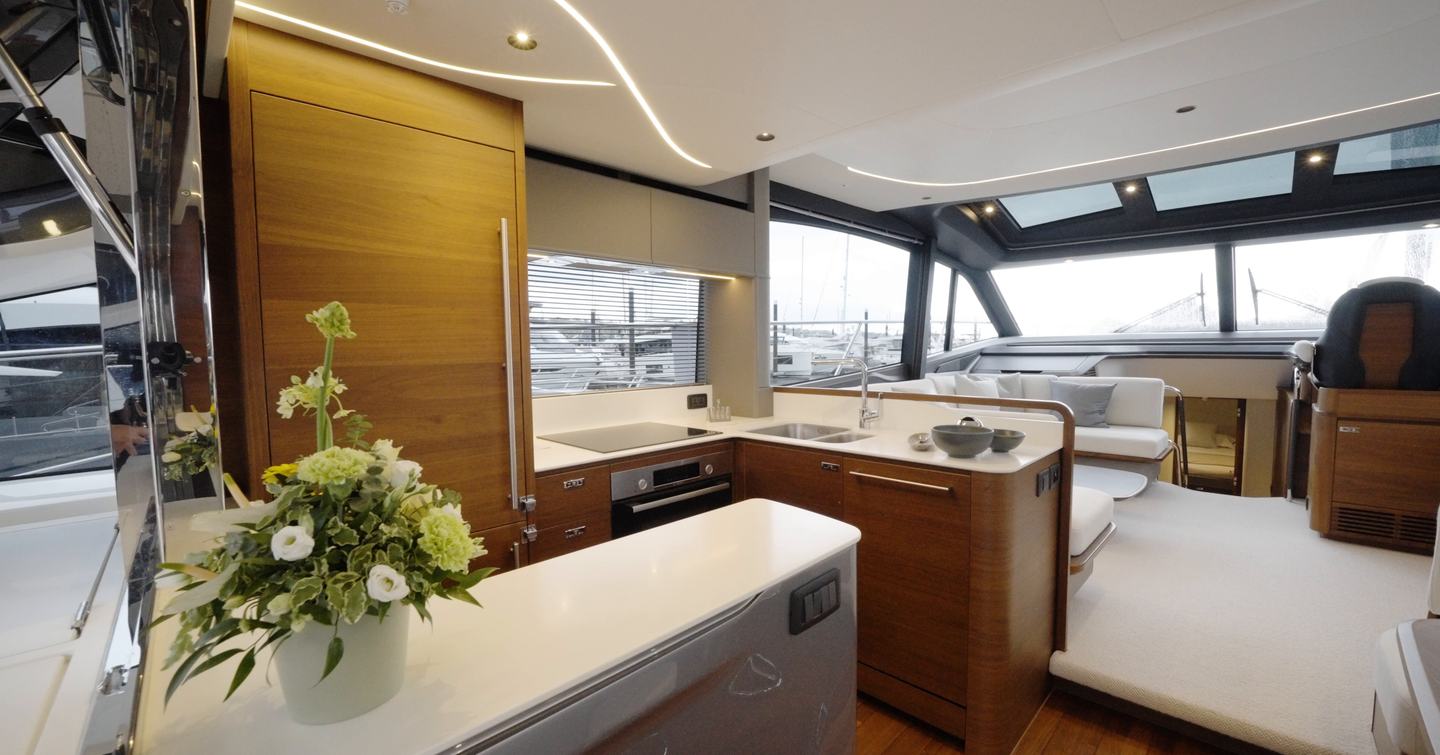 Princess S65 Mk2 main deck galley and saloon with matte walnut cabinetry and large windows