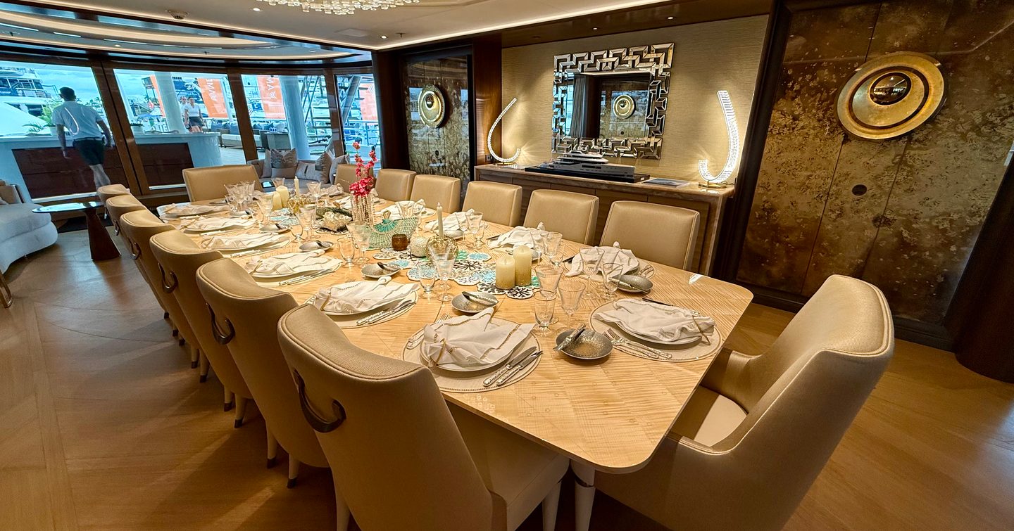 Formal dining area in the main saloon of the Amels 242 Casino Royale with seating for 14 guests.