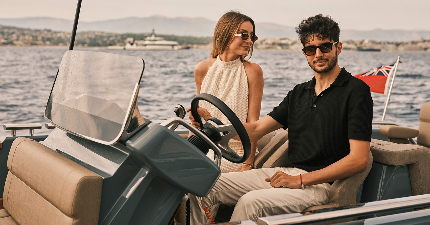 Formula 1’s Esteban Ocon with hand on wheel of William Jet Tender next to woman