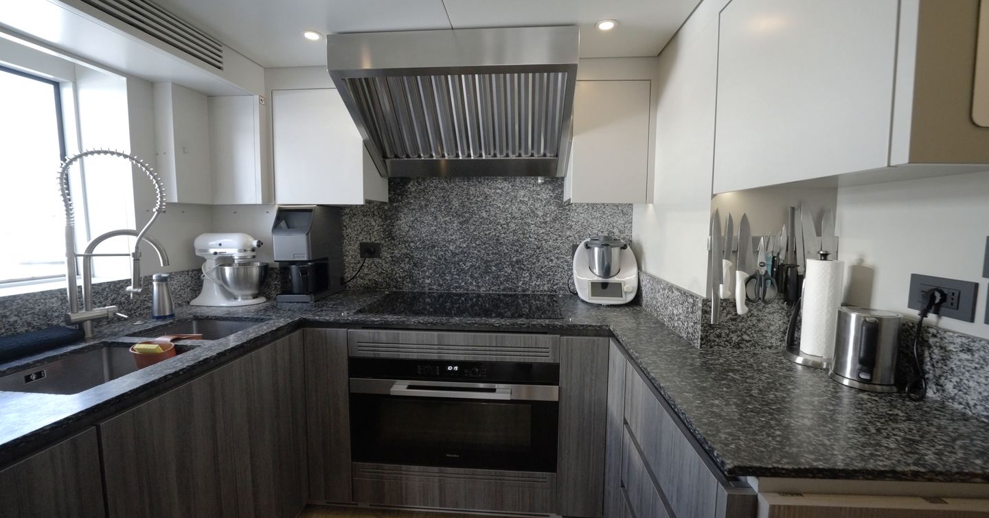 Benetti Oasis 34M crew galley with granite worktops, commercial-grade appliances and U-shaped food preparation area.