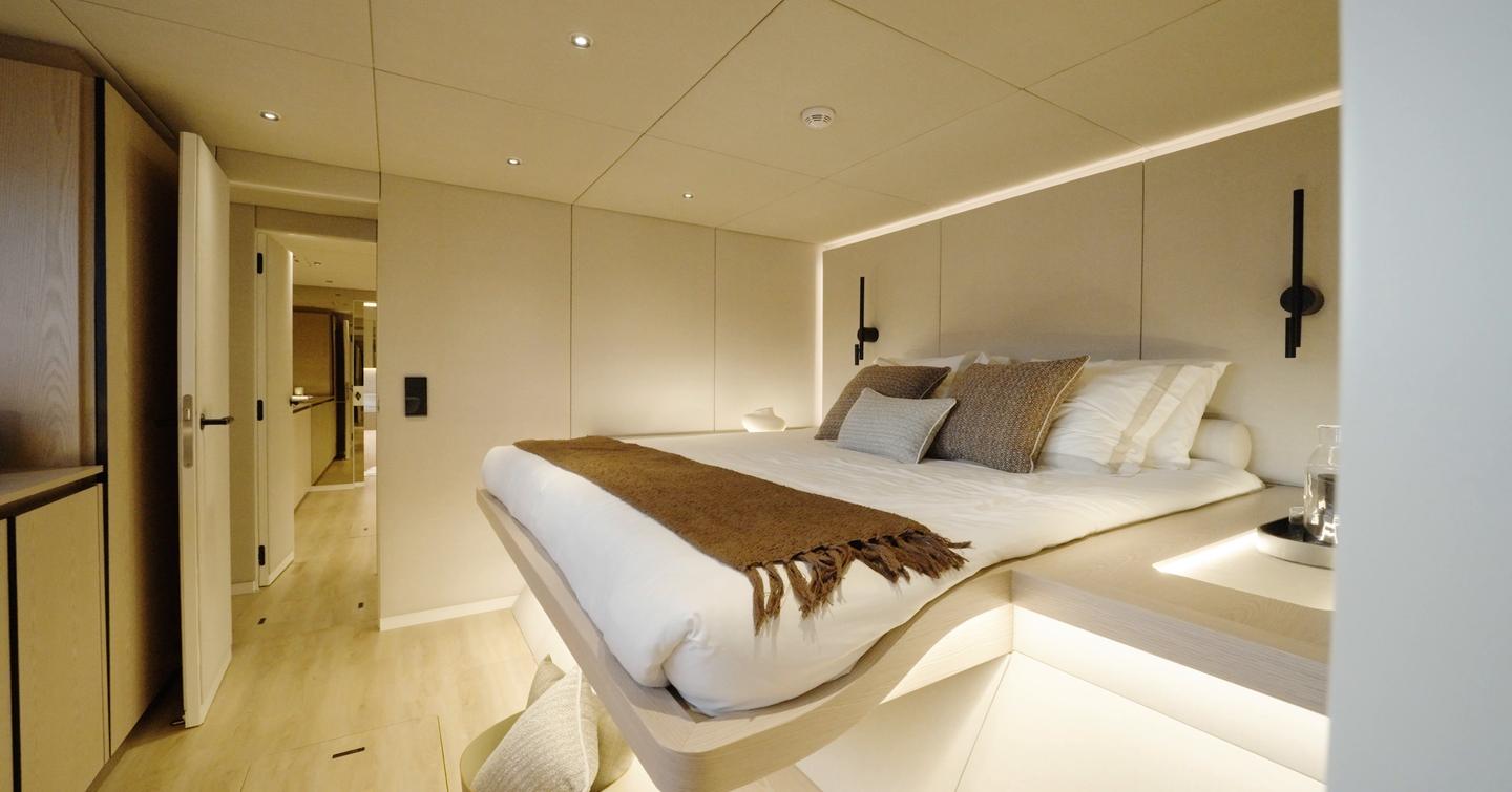 Sunreef Ultima 88 VIP guest cabin with raised double bed and pale wood finish