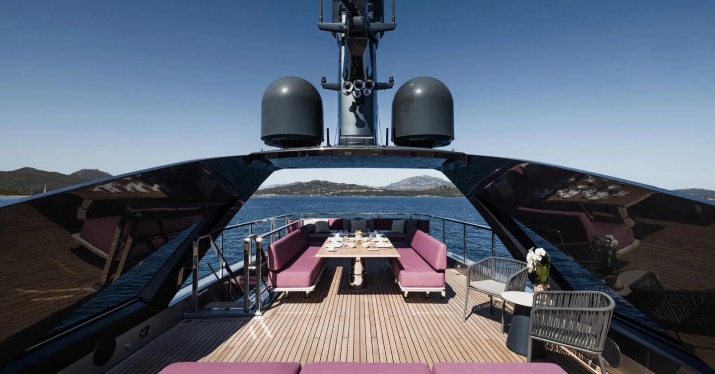 Superyacht Flying Dagger III sundeck with alfresco dining and purple sunpads 