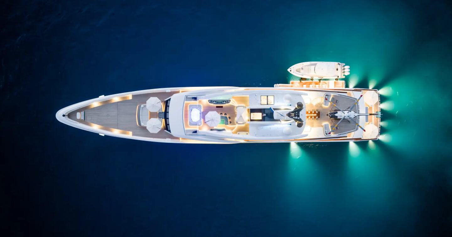 Aerial view of superyacht Vanish at anchor with underwater aft lights and tender 
