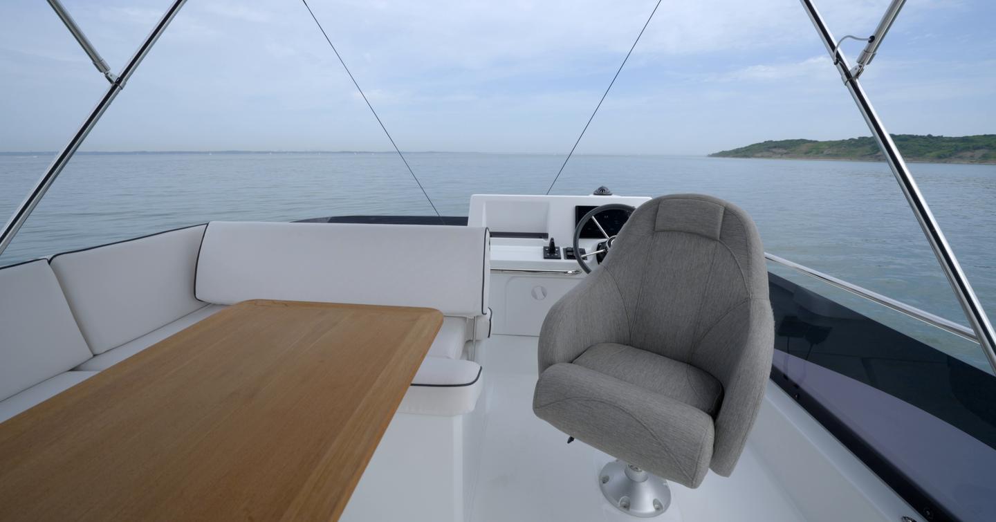 Flybridge dining area with rotating helm seat on the Beneteau Swift Trawler 37 Fly