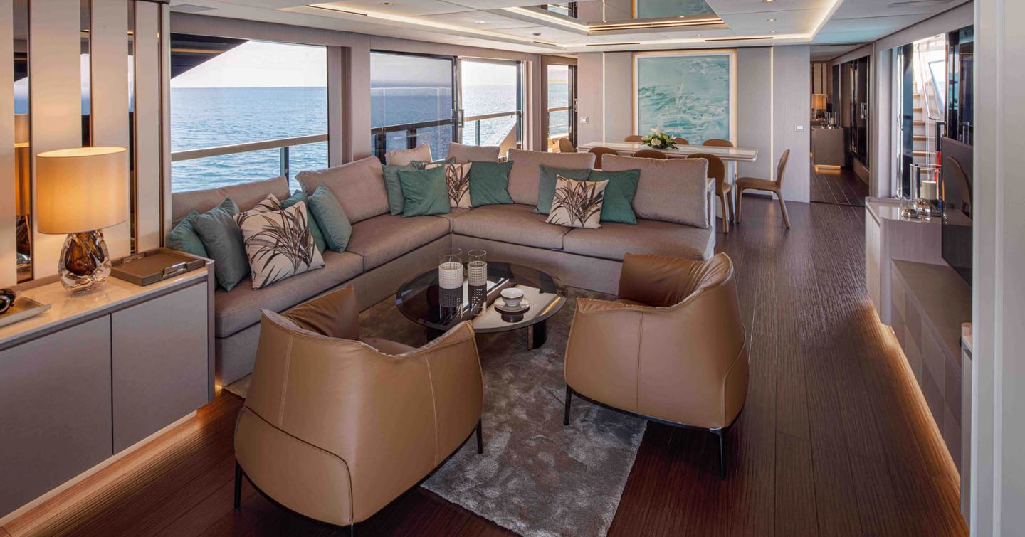 Mangusta GranSport 33 motor yacht main saloon with L-shaped seating and brown chairs