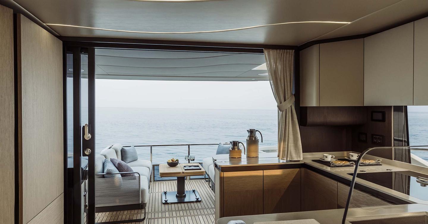 Next-Gen Absolute 52 FLY motor yacht aft indoor galley with glass sliding doors 