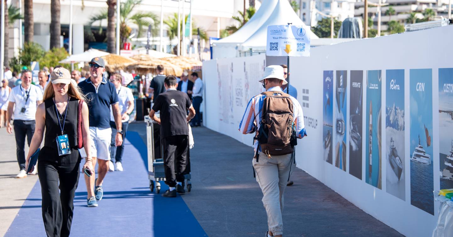 Visitors walking by exhibitor tents at the Cannes Yachting Festival
