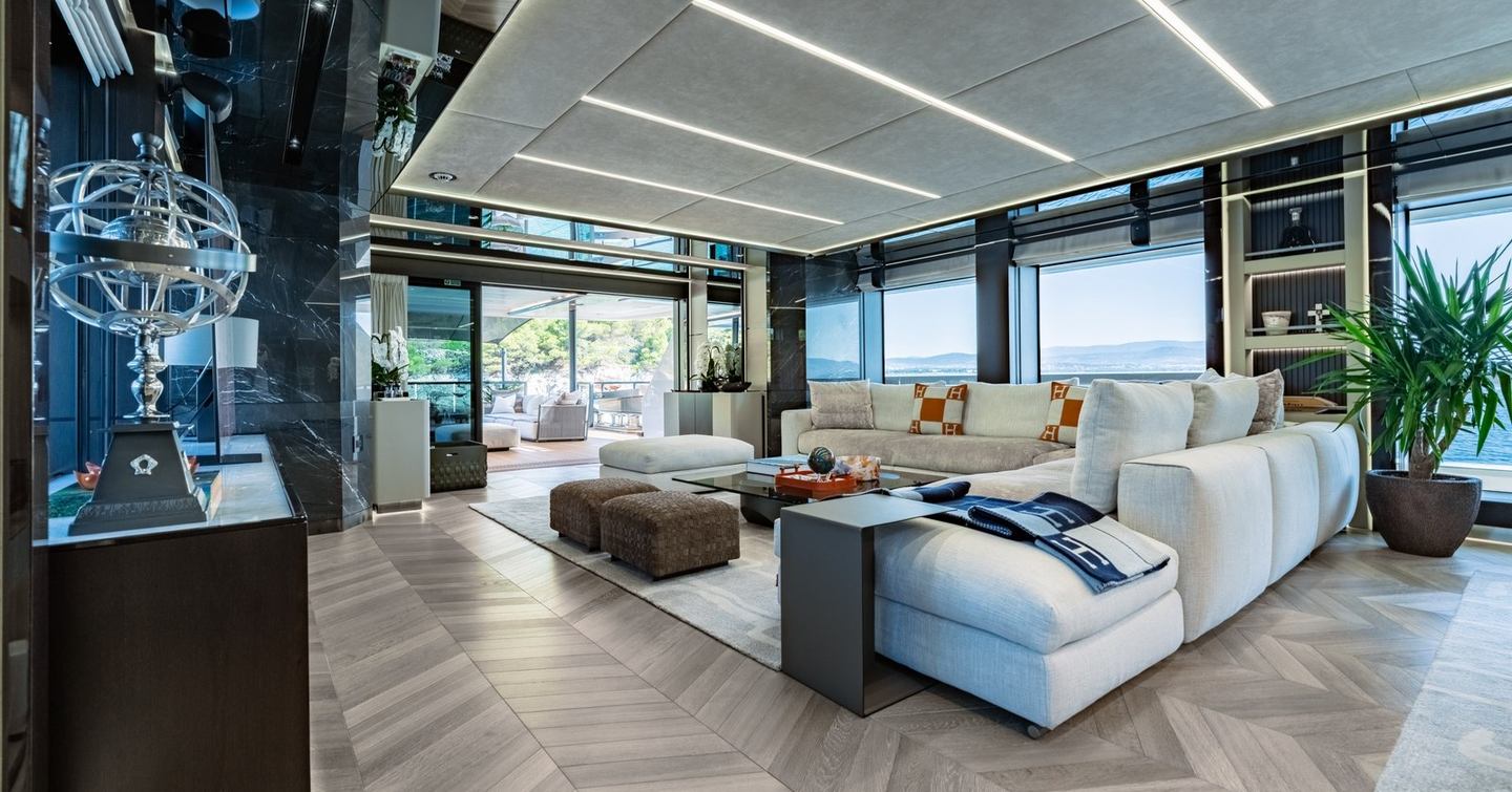 Main saloon on motor yacht Gisa, with L-shaped sofa, parquet flooring and Hermes cushions