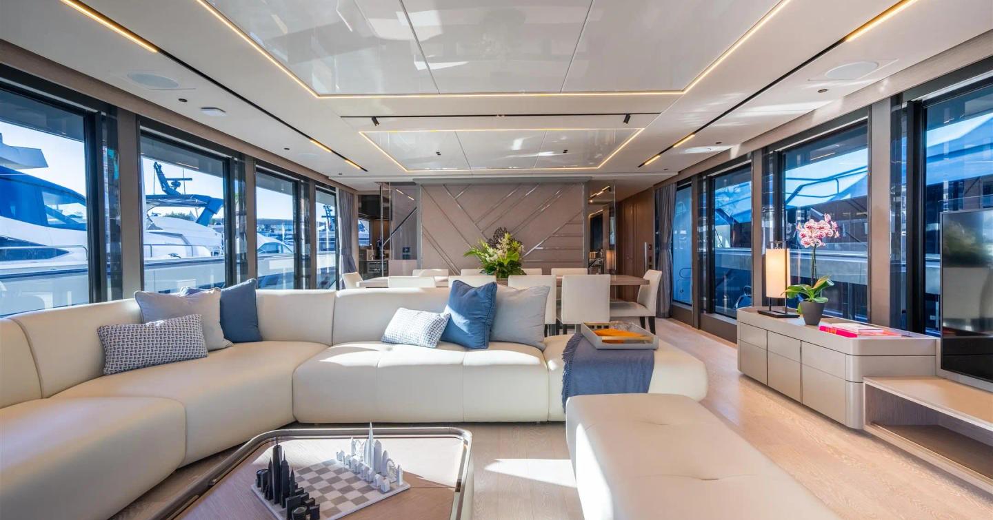 Sunseeker 100 Yacht main saloon with L-shaped sofa and blue accents