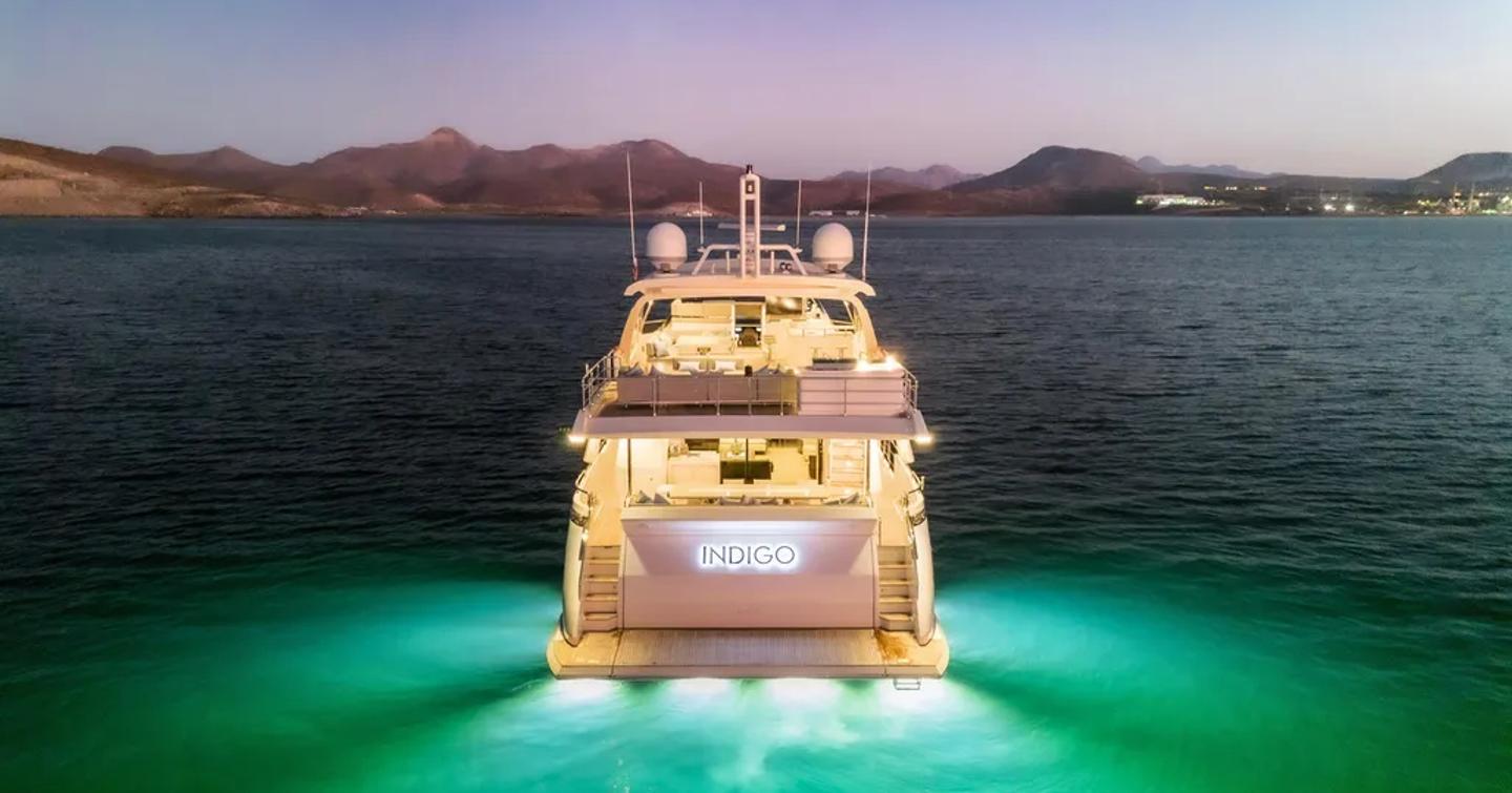 Superyacht Indigo's lit up with underwater lights at anchor