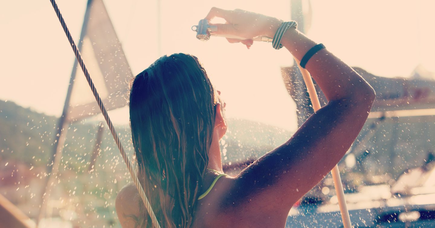 Young female showering on yacht