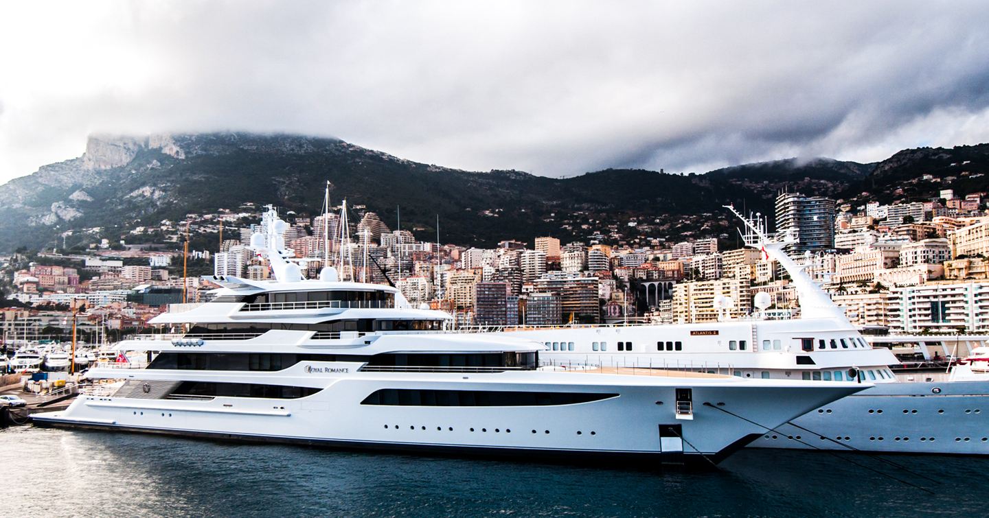 Feadship Superyacht Royal Romance docked in front of mountains 