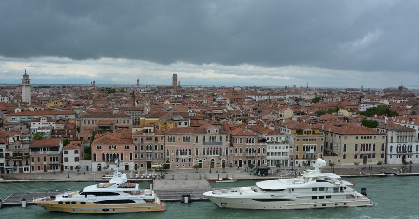 Frontal view of Venice Yacht Pier, with two motoryachts docked in foreground and Venice in background