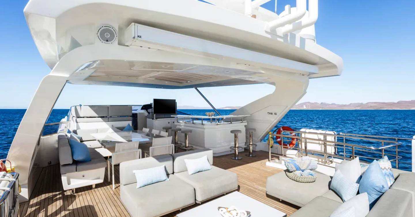 Superyacht Indigo's sundeck with sunpads and bar area