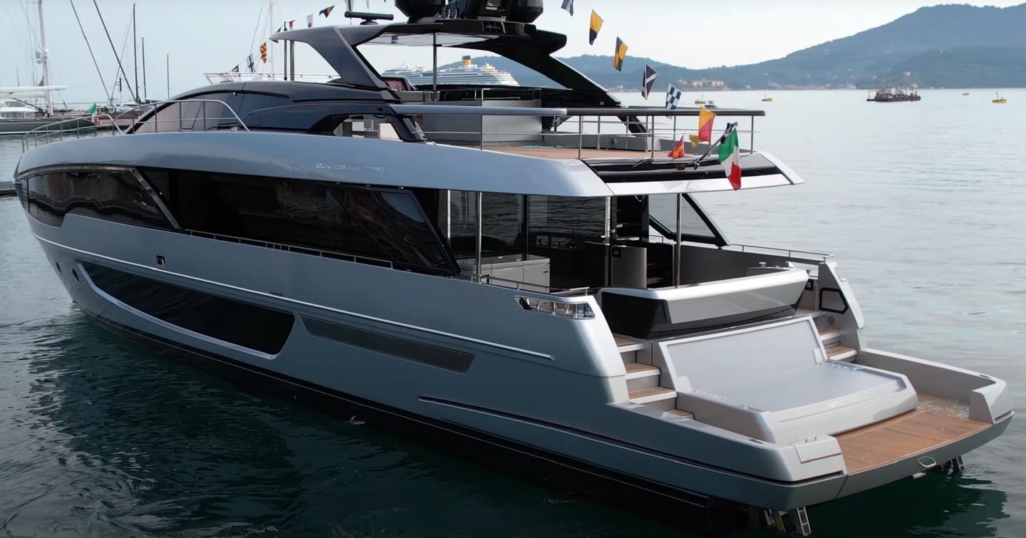 Aft view of Riva 102 Corsaro Super stern, yacht decorated with flags for launching ceremony. 