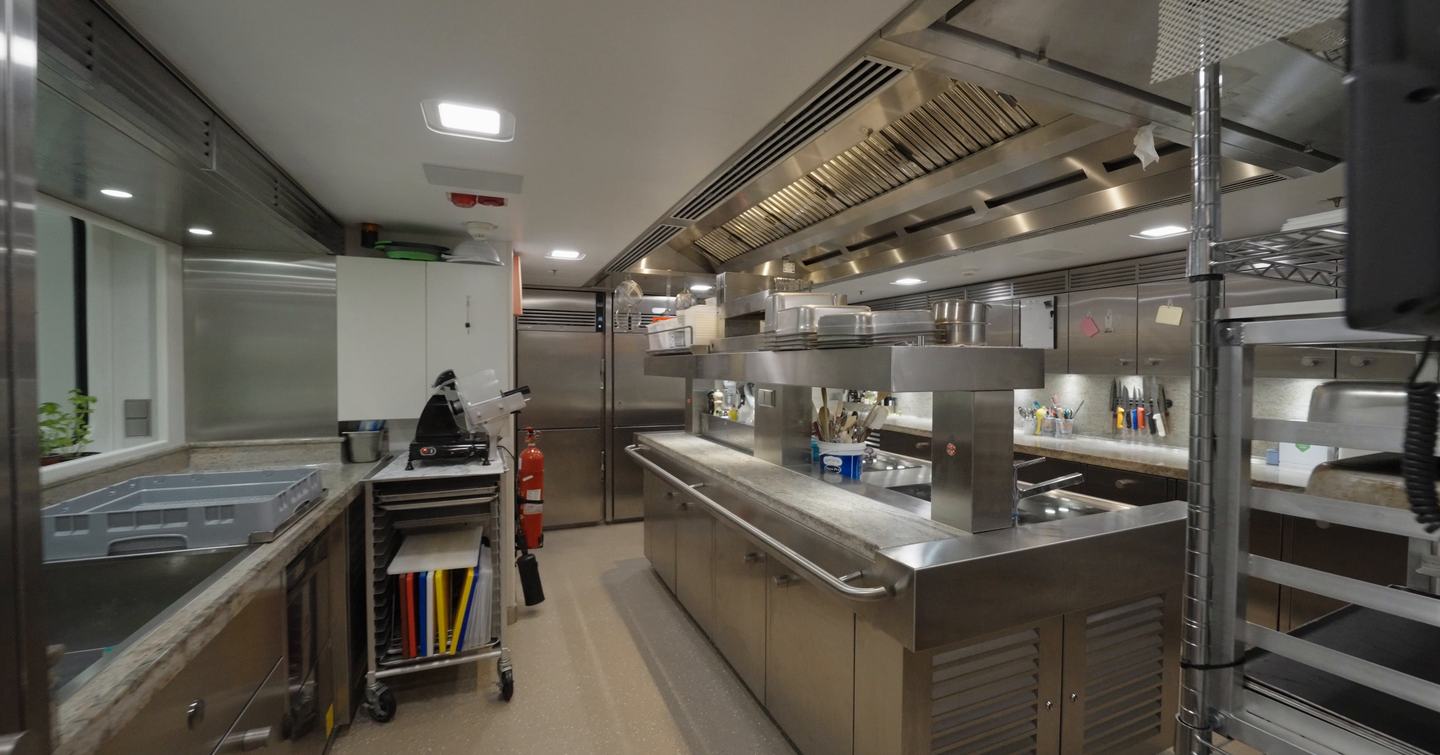 Professional stainless steel galley kitchen on the Amels 242 Casino Royale with commercial cooking equipment and preparation areas.