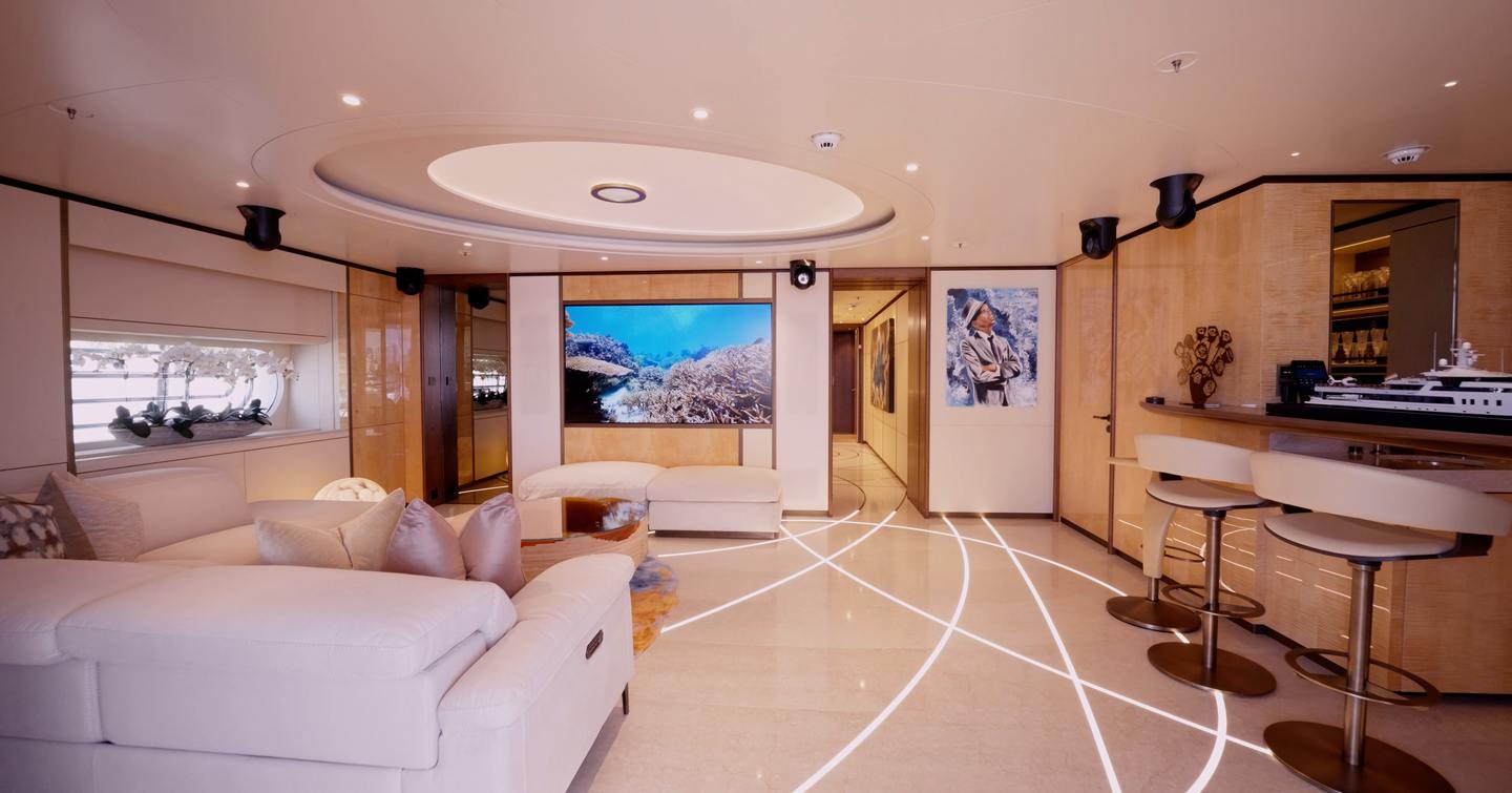 Bridge deck sky lounge on the Amels 242 Casino Royale with lounge seating, large screen and bar area.