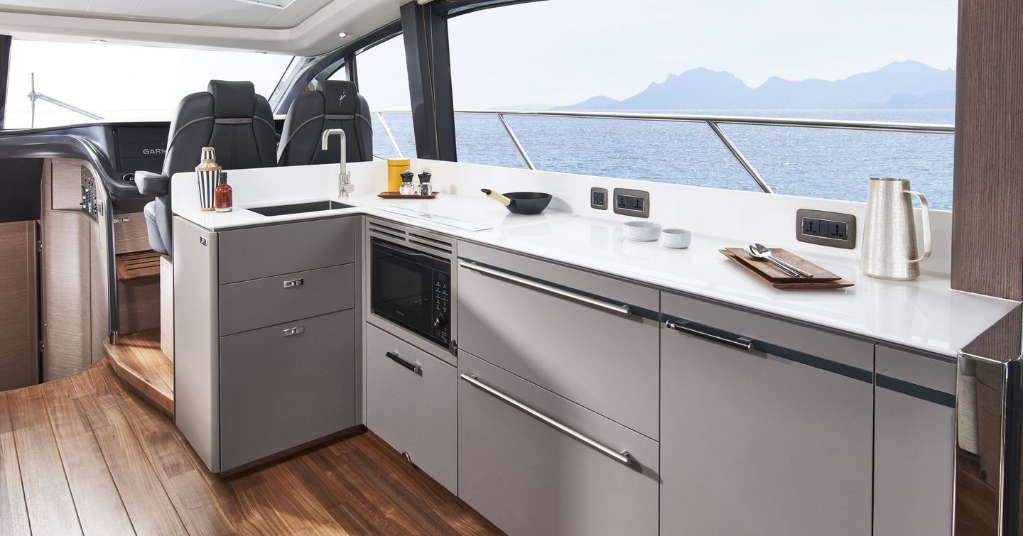 Princess V55 galley and helm layout with white worktop, under-counter refrigeration and twin helm seats in 17.81m sportsboat