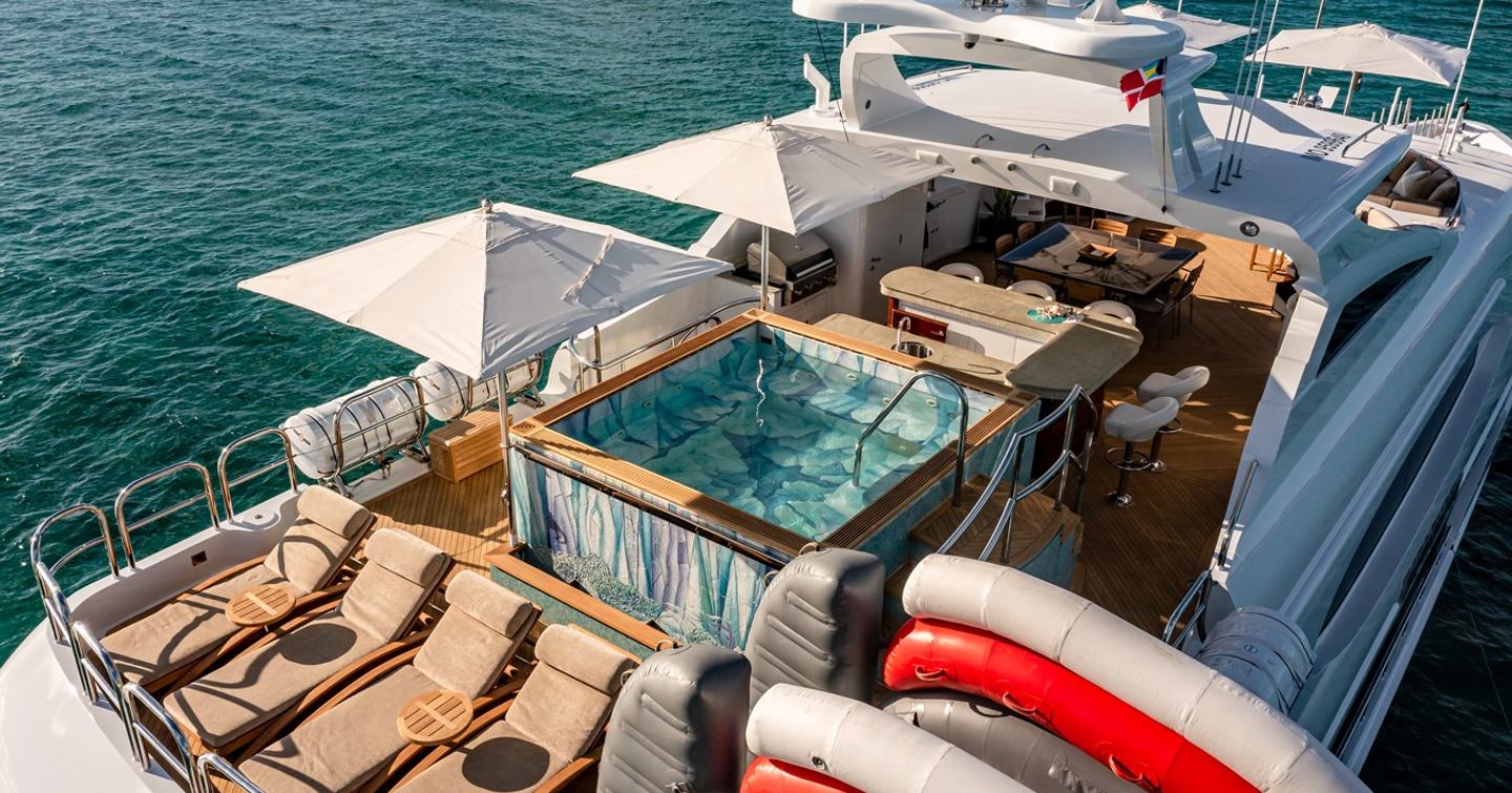 Superyacht Impromptu sundeck with beige sundecks and large central jacuzzi and bar area