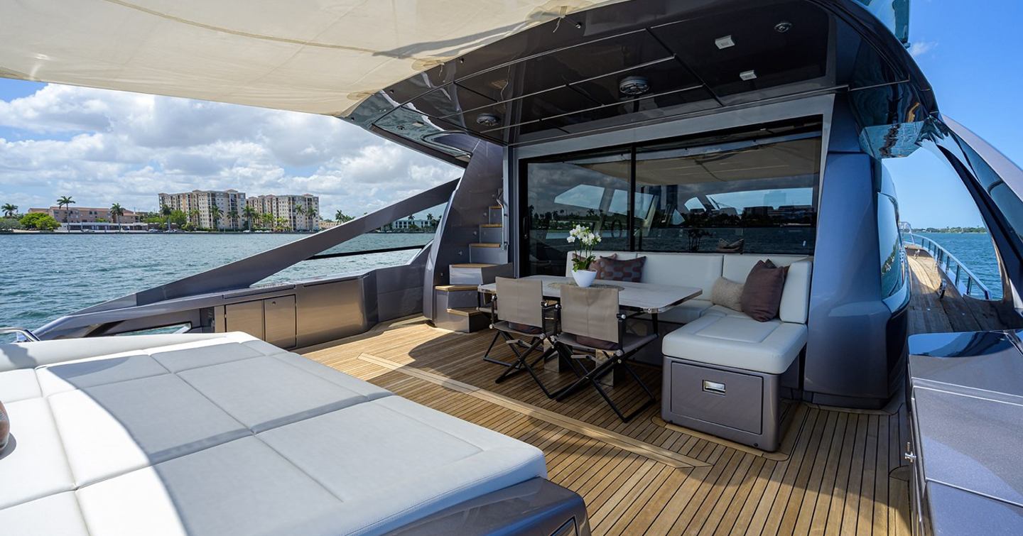 Motor yacht Shine's aft deck with sunbathing area and dining table