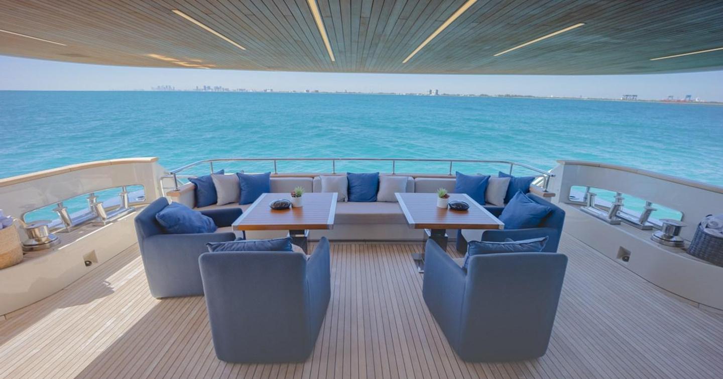 Aft deck on motor yacht Phoenix with seating area, tables and an armchair 
