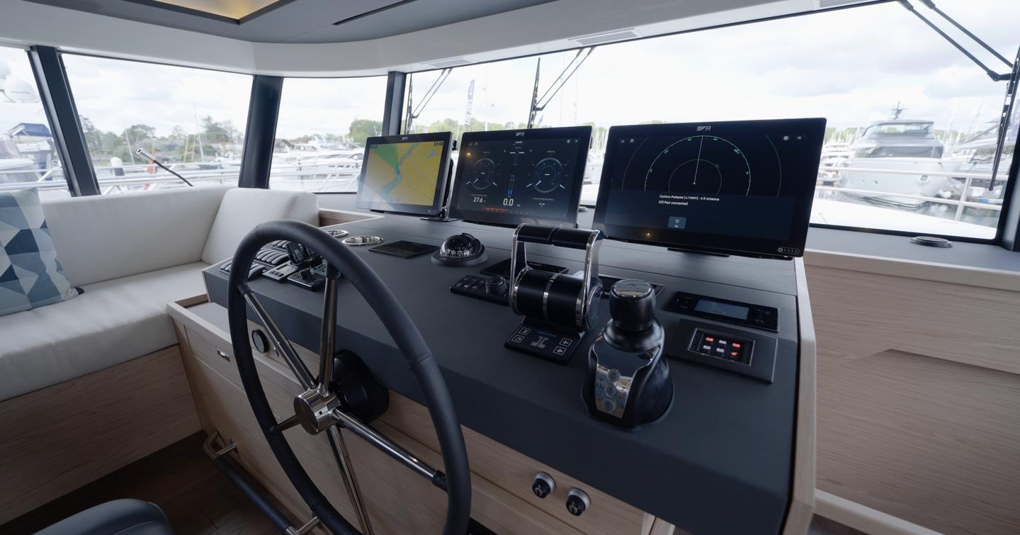 Beneteau Grand Trawler 63 lower helm with triple Raymarine displays and engine controls