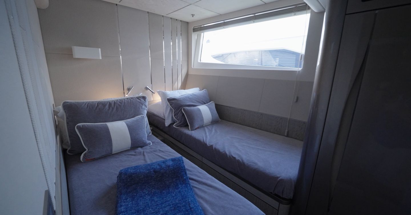 Twin guest cabin aboard the Galeon 620 Fly with side-by-side single berths and hull window.